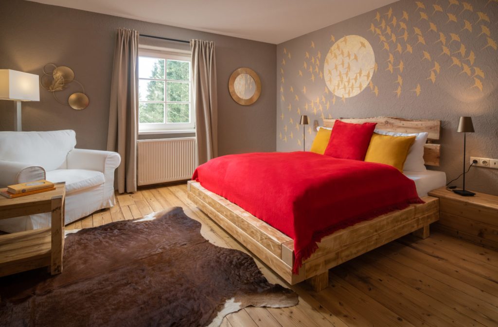 Hotelzimmer mit Doppelbett und roter Tagesdecke im Landhotel Altes Zollhaus