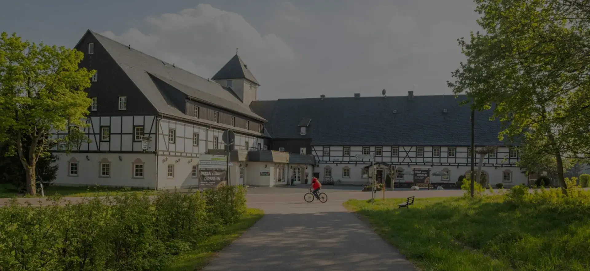 Landhotel Altes Zollhaus im Erzgebirge – historisches Fachwerkgebäude mit Turm an der Waldlichtung in Neuhermsdorf
