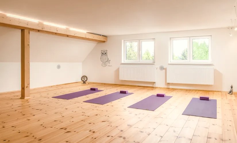 Heller Yogaraum mit Holzboden und ausgelegten Yogamatten im Landhotel Altes Zollhaus bei Altenberg – Ort des Yoga-Retreats mit Roman Richter